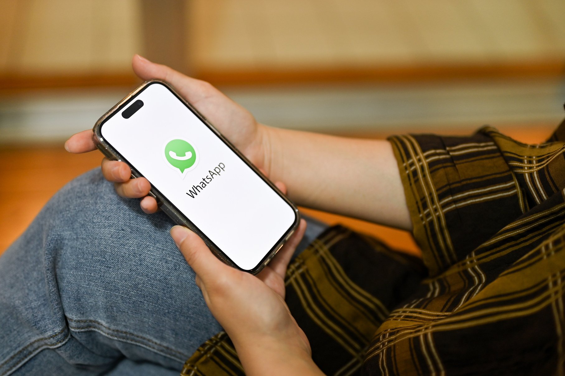 Female using her smartphone, holding a smartphone with WhatsApp